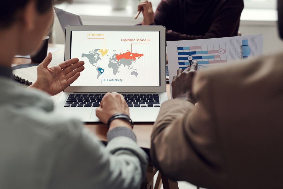 consultor seo explicando resultados de posicionamiento en una pantalla a una pyme